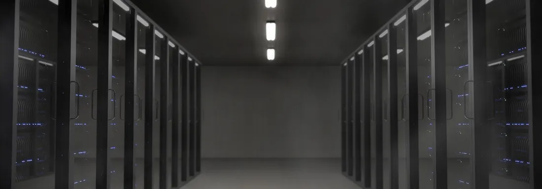 Rows of illuminated server racks in a dark data center