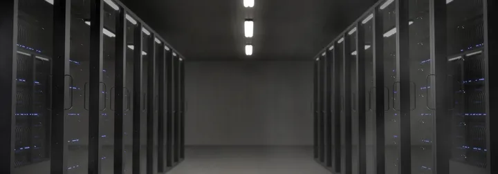 Rows of illuminated server racks in a dark data center