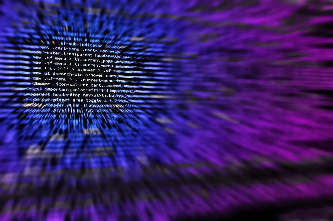Laptop screen filled with colorful source code in a dark editor