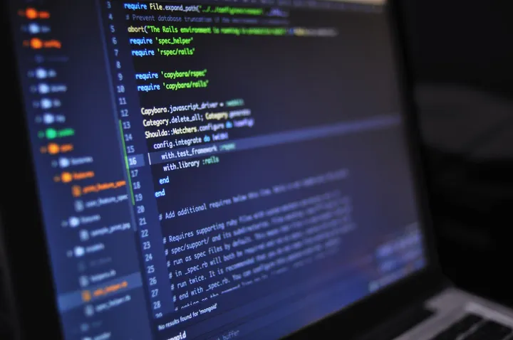 Ekran laptopa z podświetlonym kodem w edytorze o ciemnym motywie