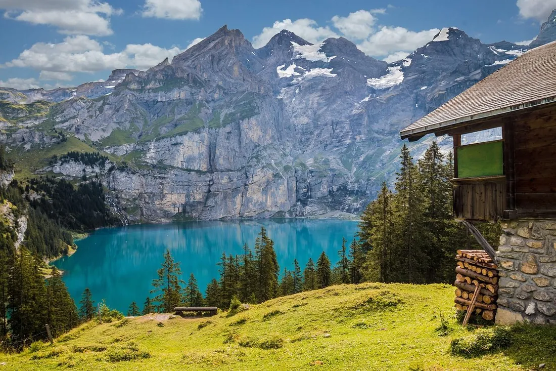 Mountain lake with a small hut and surrounding peaks