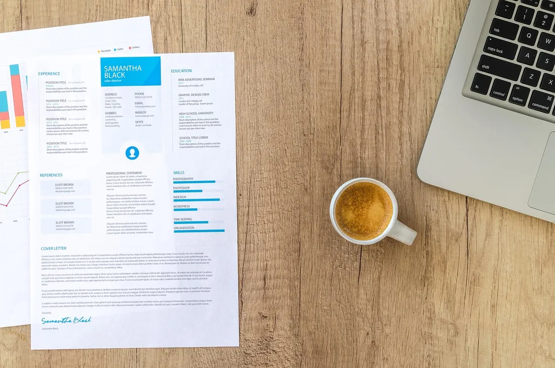 Printed interview scorecard and resume on a wooden desk beside a laptop and a cup of espresso