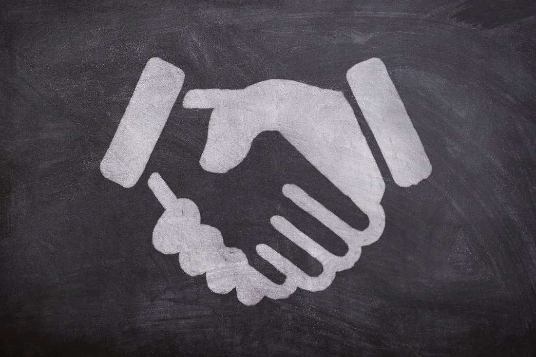 What Is an Applicant Tracking System? — two professionals shaking hands in an office