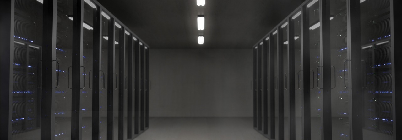 Rows of illuminated server racks in a dark data center