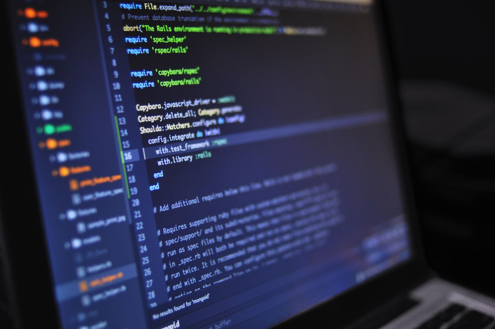 Laptop screen showing syntax-highlighted code in a dark-themed editor
