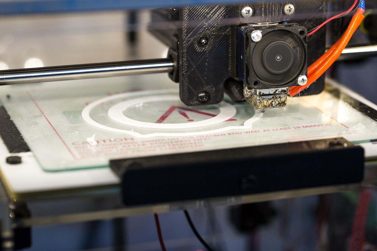 Close-up of a 3D printer's nozzle actively printing an object on its build plate
