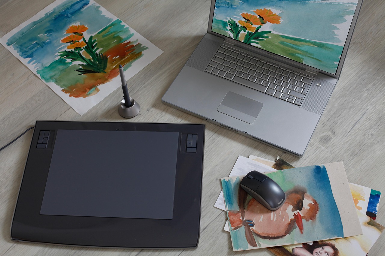 Close-up of a graphics tablet and stylus resting on a desk, surrounded by colorful abstract digital art